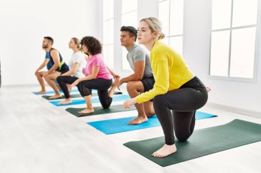 Bir grup genç, spor merkezinde yoga eğitimi alıyor..