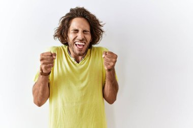 Tecrit edilmiş arka planda duran genç İspanyol adam kolları havada ve gözleri kapalı zaferi kutlarken heyecanla bekliyor. Kazanan konsept. 