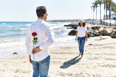 Orta yaşlı İspanyol bir adam. Plajda elinde çiçek tutan sürpriz bir kadın..