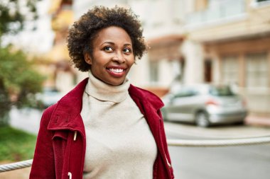 Güzel bir iş adamı Afro saçlı Amerikalı kadın şehirde mutlu ve kendinden emin bir şekilde gülümsüyor.