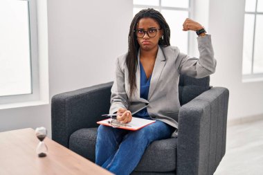Danışmanlık ofisinde örgü ören genç bir Afrikalı Amerikalı. Kol kası gösteren güçlü, kendinden emin ve gururlu biri. 