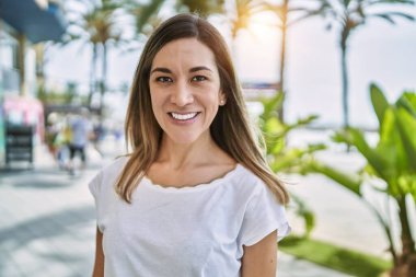 Sokakta kendinden emin gülümseyen genç İspanyol kadın.