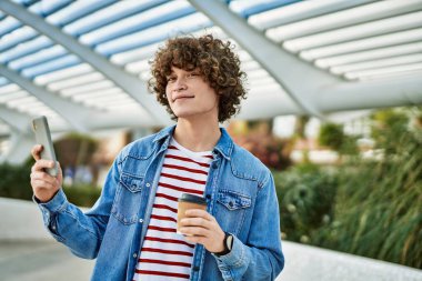 Genç İspanyol adam şehirde akıllı telefon kullanıyor.