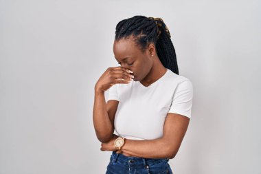 Beautiful black woman standing over isolated background tired rubbing nose and eyes feeling fatigue and headache. stress and frustration concept. 