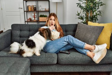 Beyaz bir kadın evde köpekle birlikte kanepede oturup film izlerken şaşırdı.