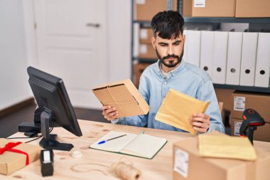 İspanyol asıllı genç bir iş adamı ofiste paketleri tutuyor.