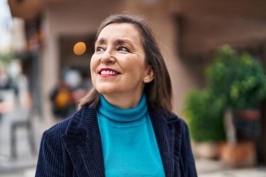 Middle age woman business executive smiling confident standing at street