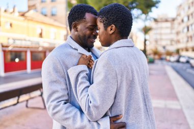 Man and woman couple hugging each other standing at street