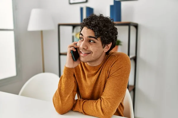 Jonge Spaanse Man Aan Het Praten Smartphone Zittend Tafel Thuis — Stockfoto