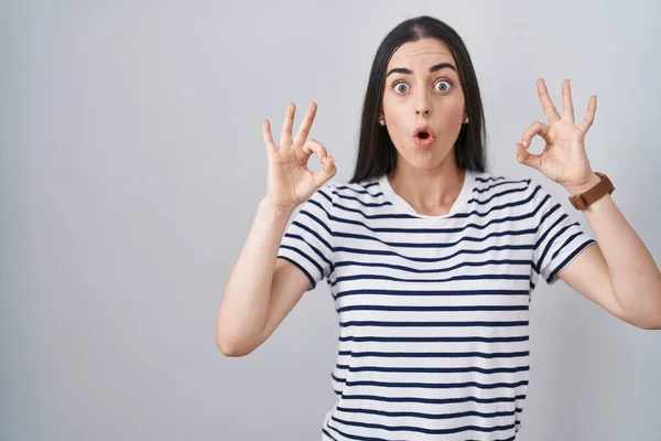 Young Brunette Woman Wearing Striped Shirt Looking Surprised Shocked Doing — Stock Photo, Image