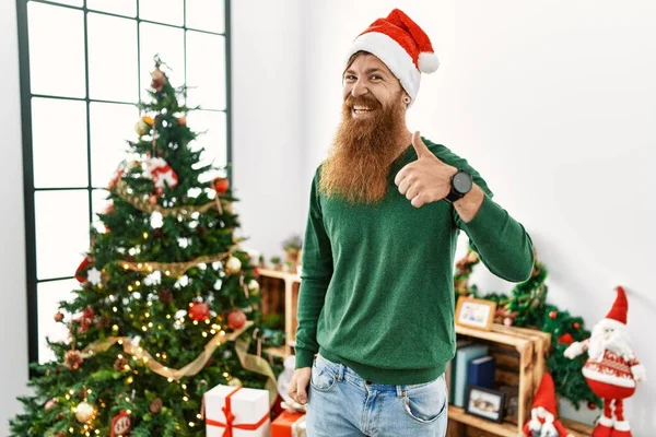 크리스마스 모자를 크리스마스 트리를 손가락을 손으로 카메라 표정을 승인하는 이성공을 — 스톡 사진