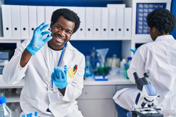 アフリカ系アメリカ人の男性と女性科学者が実験室で丸薬を持って — ストック写真