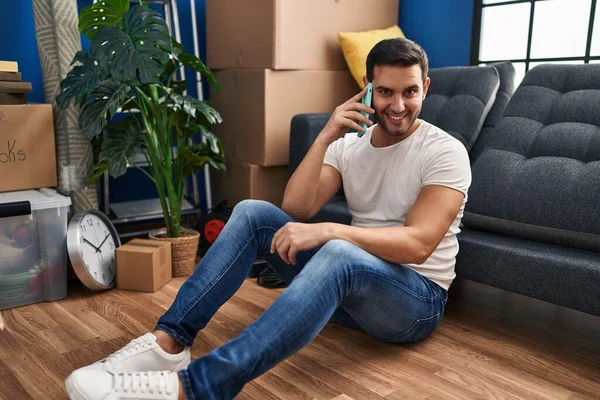 Young Hispanic Man Talking Smartphone Sitting Floor New Home — Stock Fotó