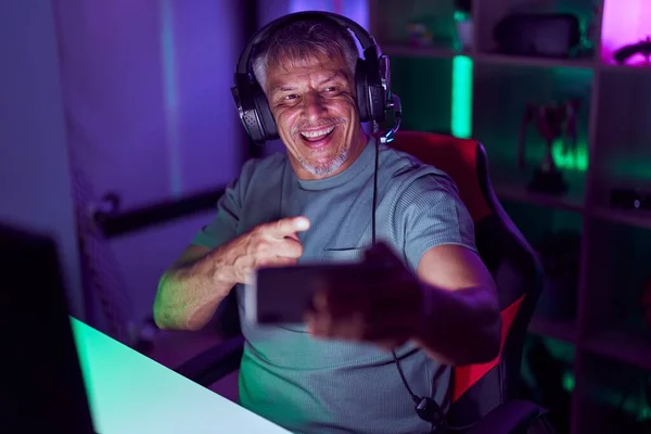 ヒスパニック系の男とともに白髪再生ビデオゲームスマートフォン笑顔幸せなポインティングとともに手と指 — ストック写真