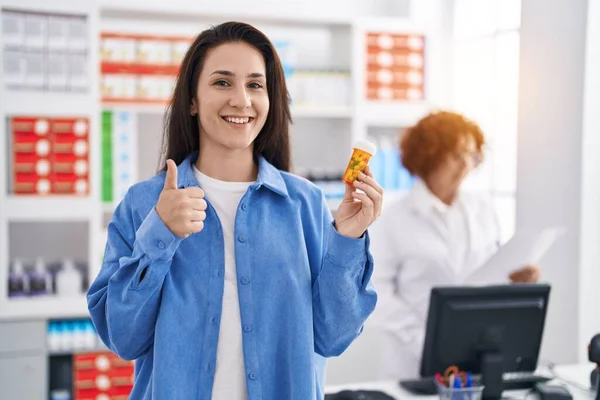 Joven Morena Sosteniendo Pastillas Farmacia Sonriendo Feliz Positiva Pulgar Hacia — Foto de Stock