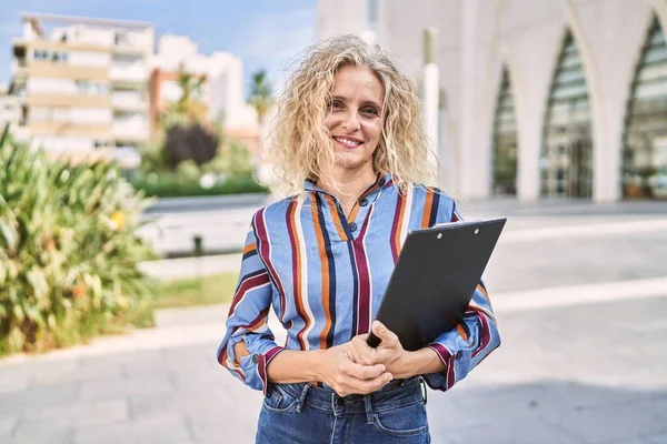 Middelbare Leeftijd Blonde Vrouw Glimlachen Zelfverzekerd Holding Klembord Straat — Stockfoto