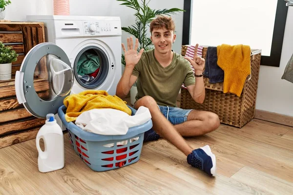Junger Kaukasier Legt Schmutzige Wäsche Die Waschmaschine Und Zeigt Mit — Stockfoto