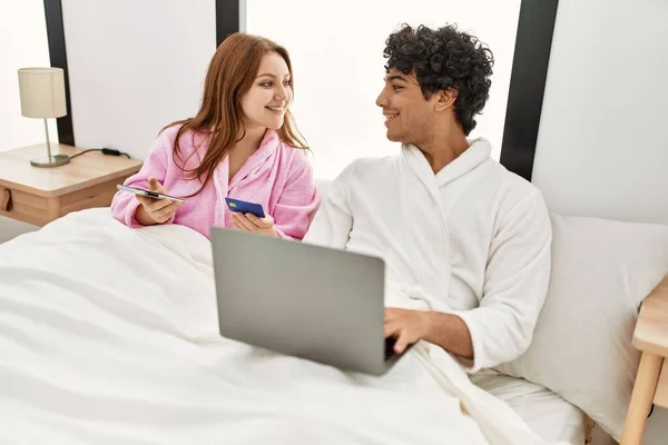 Casal Jovem Sorrindo Feliz Usando Laptop Smartphone Cartão Crédito Quarto — Fotografia de Stock