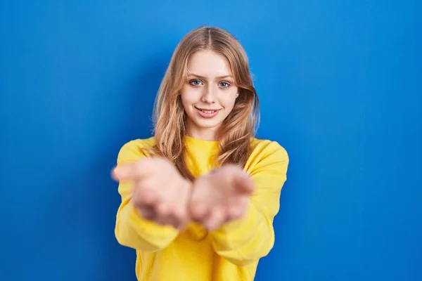 Mujer Caucásica Joven Pie Sobre Fondo Azul Sonriendo Con Las —  Fotos de Stock