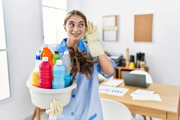 Jovem Loira Vestindo Uniforme Limpeza Segurando Produtos Limpeza Sorrindo Com — Fotografia de Stock