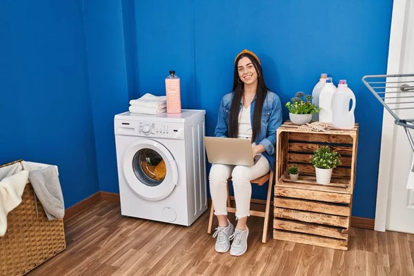 Young Beautiful Hispanic Woman Using Laptop Waiting Washing Machine Laundry — Fotografia de Stock