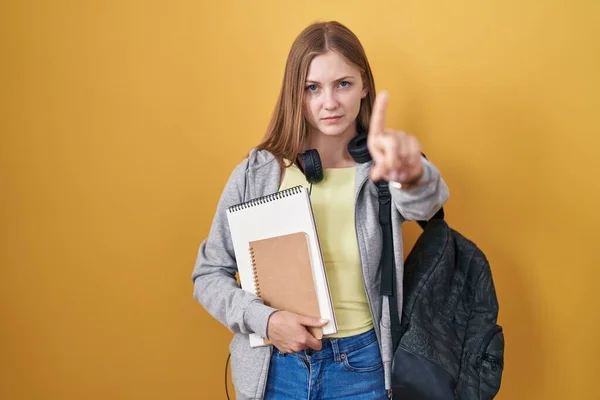 Young Caucasian Woman Wearing Student Backpack Holding Books Pointing Finger — 图库照片