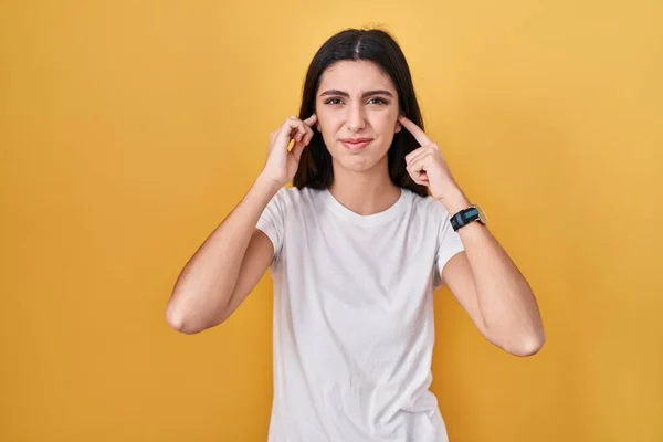 Young Beautiful Woman Standing Yellow Background Covering Ears Fingers Annoyed — Foto de Stock