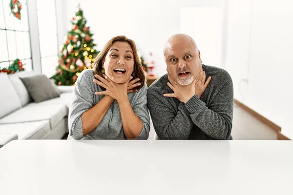 Middle Age Hispanic Couple Sitting Table Christmas Tree Shouting Suffocate — 图库照片