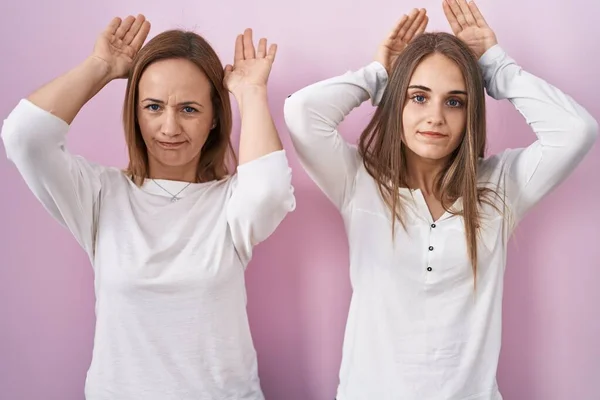 Middle Age Mother Young Daughter Standing Pink Background Doing Bunny — ストック写真