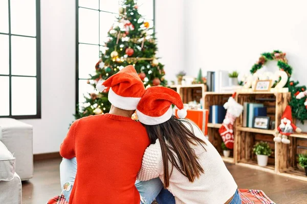 Young Latin Couple Back View Sitting Floor Looking Christmas Tree — 스톡 사진