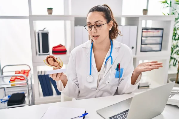 Young Beautiful Hispanic Woman Gynecologist Holding Anatomical Model Fetus Speaking — Stock Photo, Image