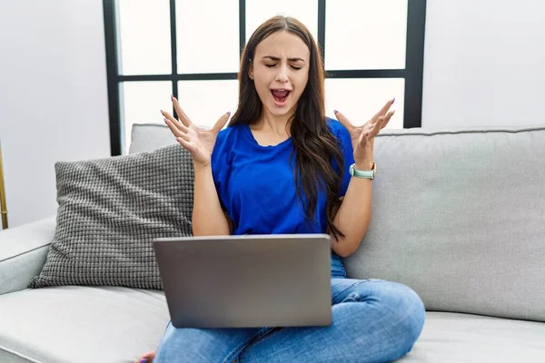 Genç Esmer Kadın Evde Dizüstü Bilgisayar Kullanarak Başarının Çılgınlığını Kutluyor — Stok fotoğraf