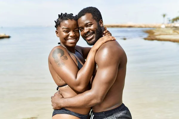 穿着泳衣在海滩拥抱的年轻的非洲游客夫妇 — 图库照片