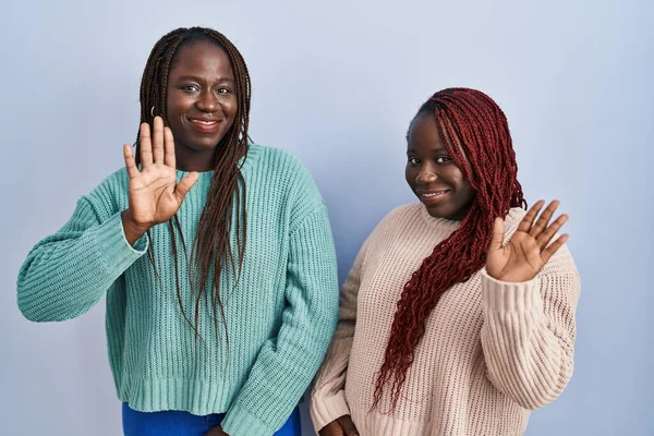 Twee Afrikaanse Vrouw Staan Blauwe Achtergrond Afzien Van Hallo Zeggen — Stockfoto