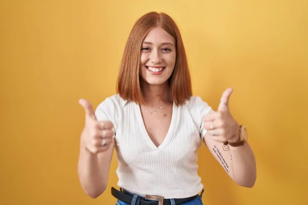 Young Redhead Woman Standing Yellow Background Success Sign Doing Positive — Zdjęcie stockowe