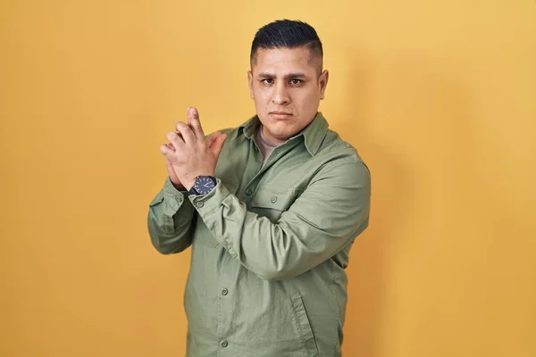 Hispanic Young Man Standing Yellow Background Holding Symbolic Gun Hand — Stock Photo, Image