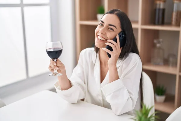 잠꾸러기 여자가 스마트폰으로 이야기하고 집에서 와인을 마십니다 — 스톡 사진