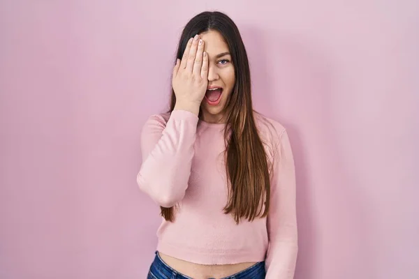 Genç Esmer Kadın Pembe Arka Planda Duruyor Bir Gözünü Eliyle — Stok fotoğraf