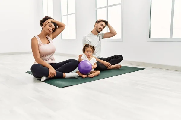 Couple and daughter stretching at sport center