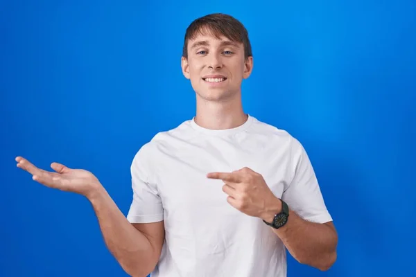 Caucasian Blond Man Standing Blue Background Amazed Smiling Camera While — Foto Stock