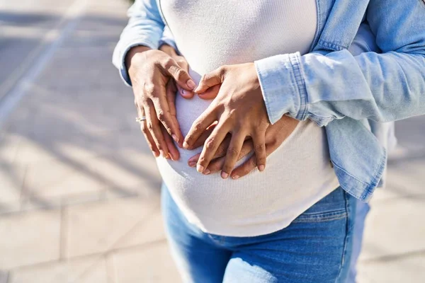 Young Latin Couple Expecting Baby Touching Belly Hugging Each Other — Stockfoto