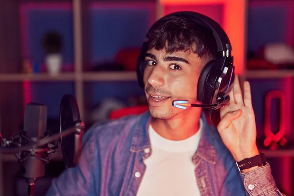 Young Hispanic Man Playing Video Games Smiling Hand Ear Listening — Foto de Stock