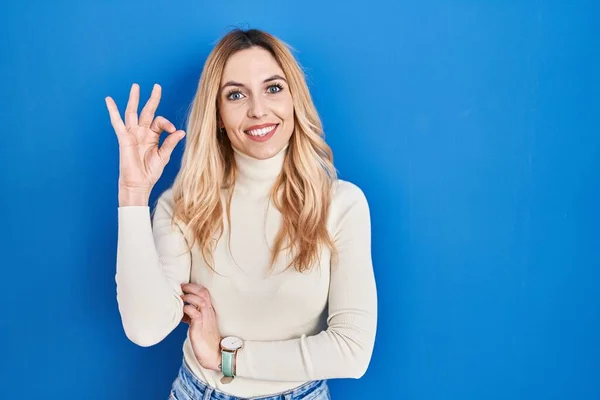 Giovane Donna Caucasica Piedi Sopra Sfondo Blu Sorridente Positivo Facendo — Foto Stock