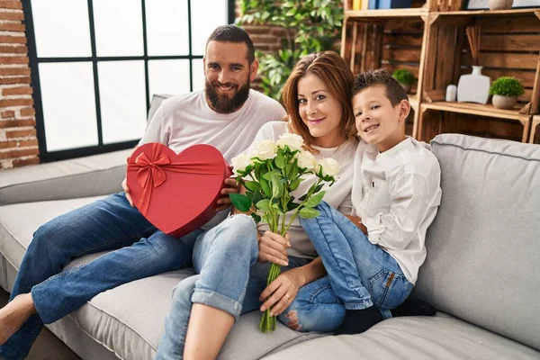 Family surprise mother with gift and flowers at home