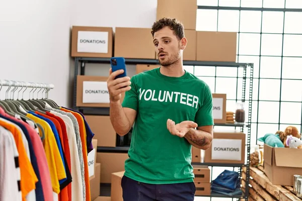 Jonge Spaanse Man Vrijwilligersuniform Met Videogesprek Een Liefdadigheidscentrum — Stockfoto