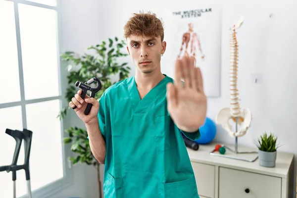 Young Caucasian Physio Man Holding Hand Grip Train Muscle Clinic — Stok fotoğraf