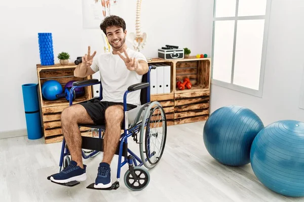 Fizyoterapi Kliniğinde Tekerlekli Sandalyede Oturan Spanyol Adam Kameraya Bakıp Zafer — Stok fotoğraf