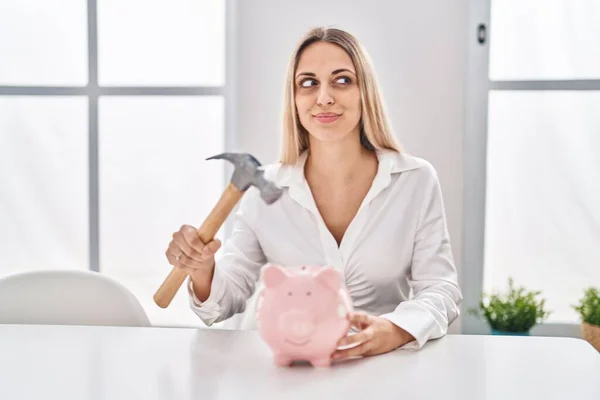 Jovem Loira Segurando Porquinho Banco Martelo Sorrindo Olhando Para Lado — Fotografia de Stock