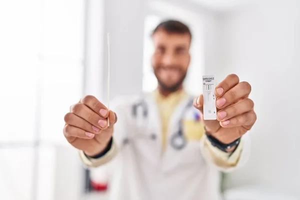 Young Hispanic Man Wearing Doctor Uniform Holding Covid Antigen Test — Stockfoto