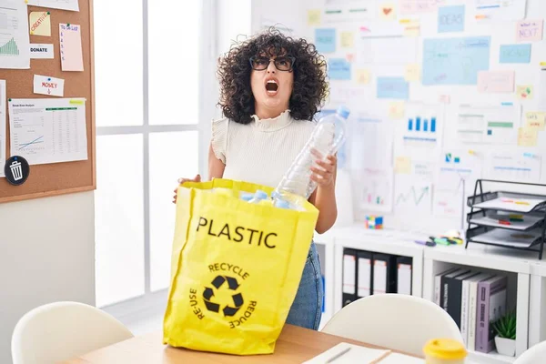 若いです中東女性保持リサイクルバッグとともにプラスチックボトルでオフィス怒っていると怒っている叫び欲求不満と激怒 怒りで叫んで検索アップ — ストック写真